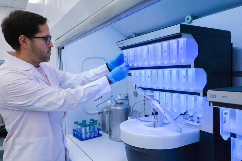 Científico de UOVO preparando muestras en equipo de síntesis de péptidos en laboratorio biotecnológico